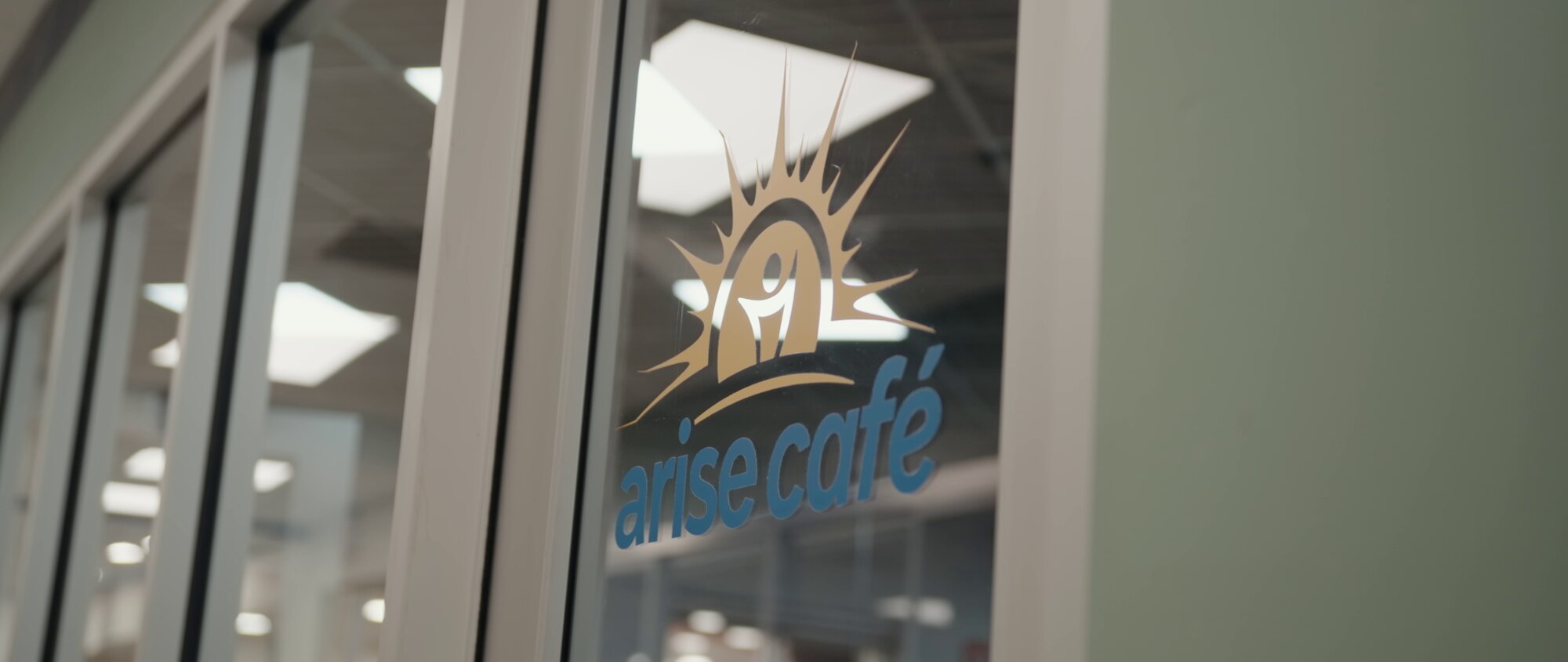Arise Café logo on the storefront glass